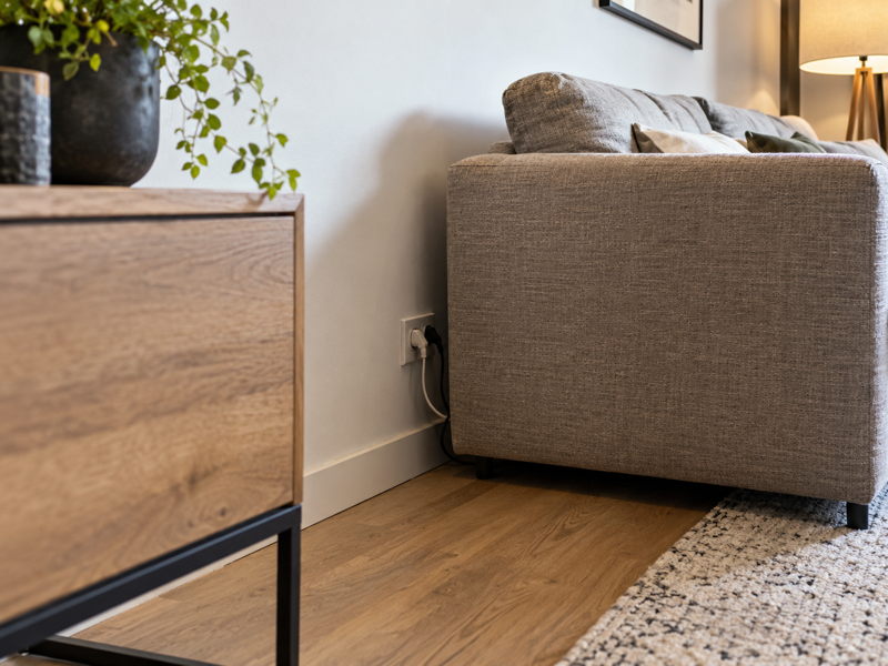 Prise électrique difficile d’accès derrière un canapé dans un logement